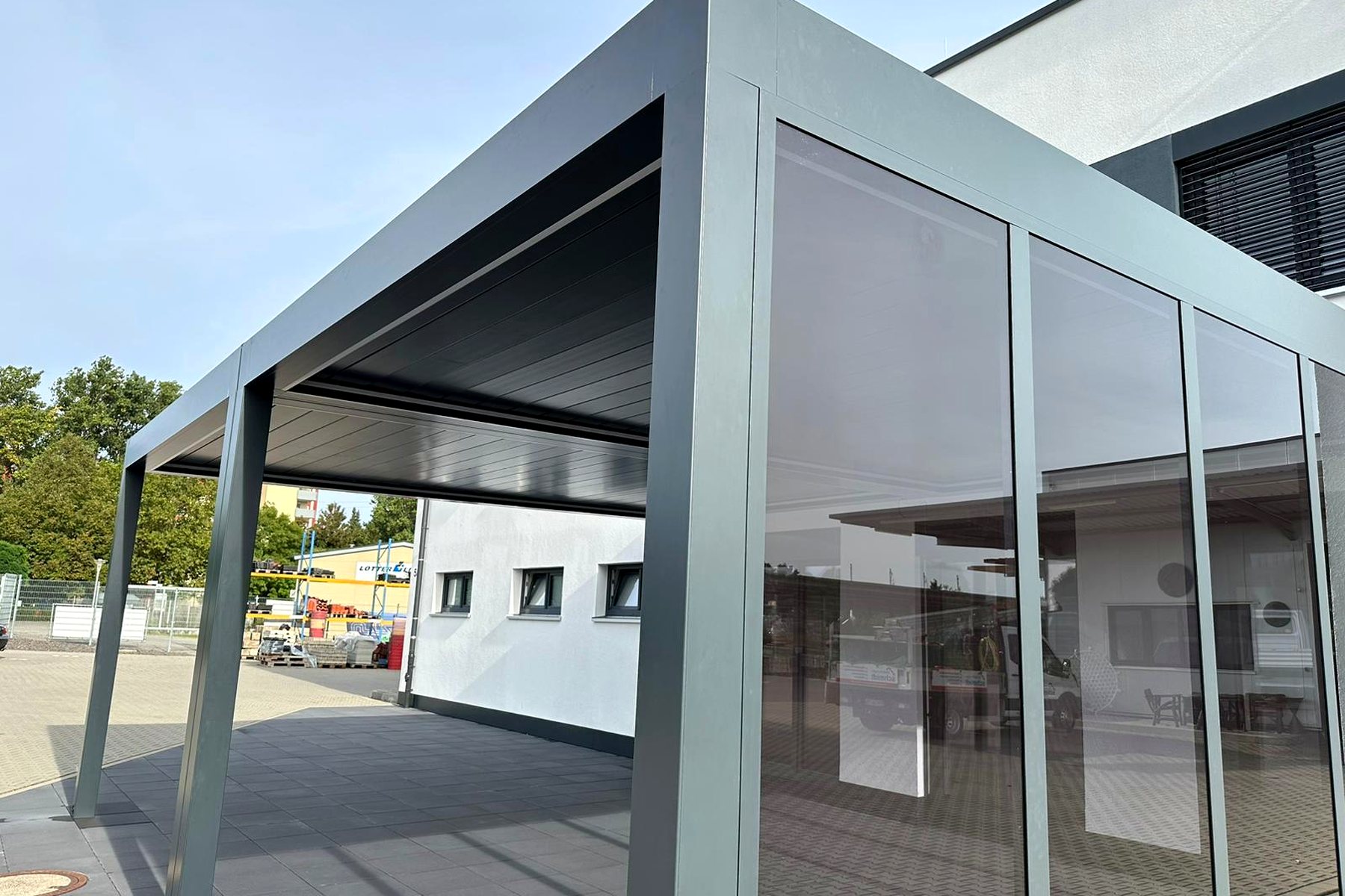 Lamellendach in hellem Grauton mit seitlichen Glaselementen