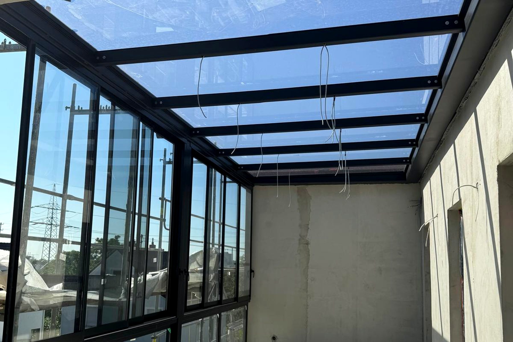 Verglaster Panoramaraum mit Glasdach und Blick in den Garten