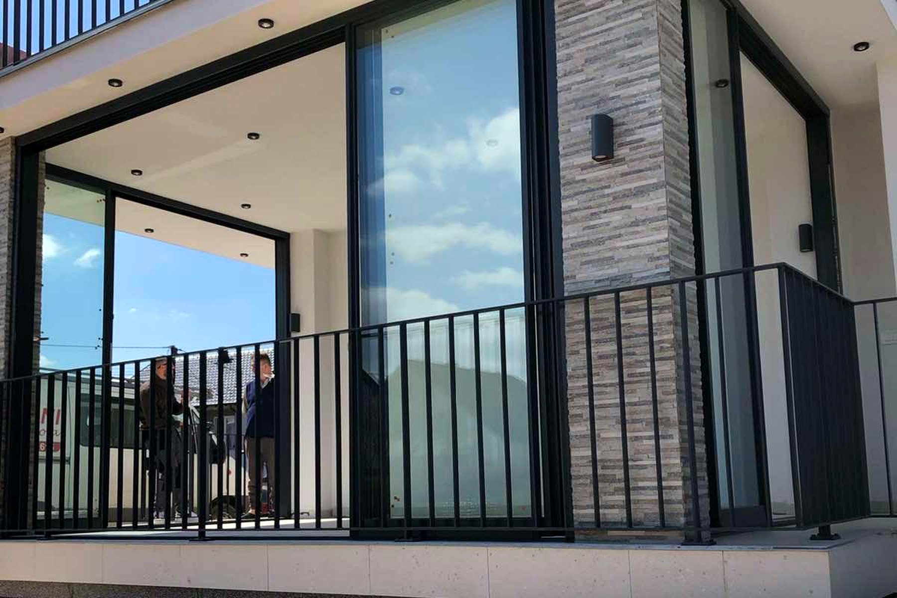 Glas-Schiebewand an einer Terrasse mit dunklen Rahmenprofilen