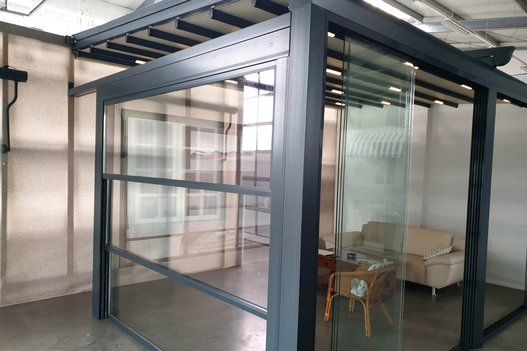 Pergola mit rahmenloser Glasfront und Sichtschutzelement an der Seite